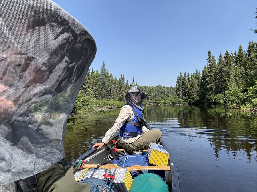 Both paddlers in bug head nets on the final paddle to the take-out.